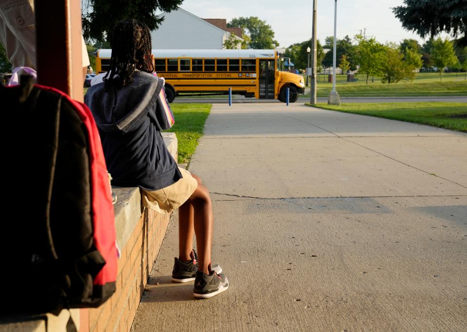 Faith Harris, 11, watches a school bus as she waits in front of Windsor STEM Academy in Linden for the first day of districtwide in-person classes to begin Monday for Columbus City Schools. 
Mandatory Credit: Barbara J. Perenic/Columbus Dispatch