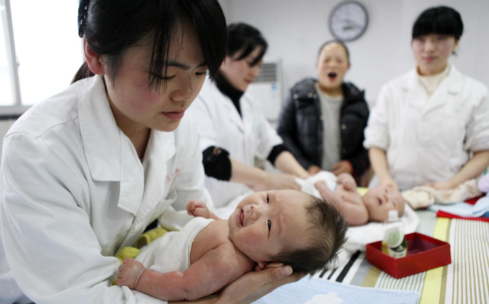 This photograph taken on December 15, 2016, shows a nurse holding a baby at an infant care centre in Yongquan, in Chongqing municipality, in southwest China. 
China had one million more births in 2016 than in 2015, following the end of the one-child policy at the end of 2015. / AFP PHOTO / STR        (Photo credit should read STR/AFP via Getty Images)