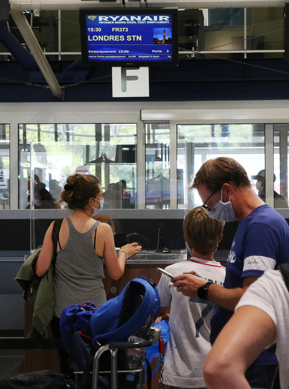 People check-in for a flight to London at the Biarritz airport, southwestern France, Friday Aug.14, 2020. British holidaymakers in France were mulling whether to return home early Friday to avoid having to self-isolate for 14 days following the U.K. government's decision to reimpose quarantine restrictions on France amid a recent pick-up in coronavirus infections. (AP Photo/Bob Edme)