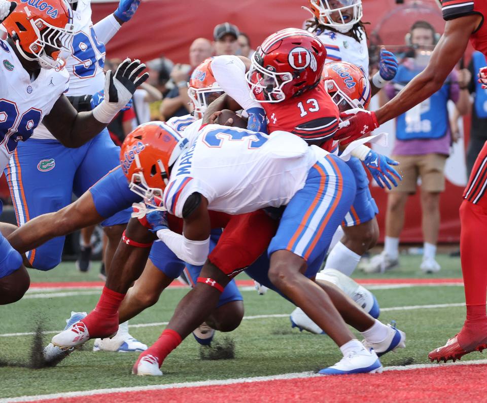 Utah Utes quarterback Nate Johnson (13) scores a touchdown against the Florida Gators.