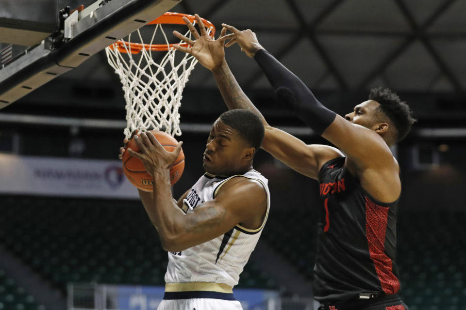 Georgia Tech forward Moses Wright (5) grabs a rebound away from Houston center Chris Harris Jr. (1) during the first half of an NCAA college basketball game Monday, Dec. 23, 2019, in Honolulu. (AP Photo/Marco Garcia)