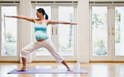 Pregnant woman practicing yoga - Credit: Andersen Ross