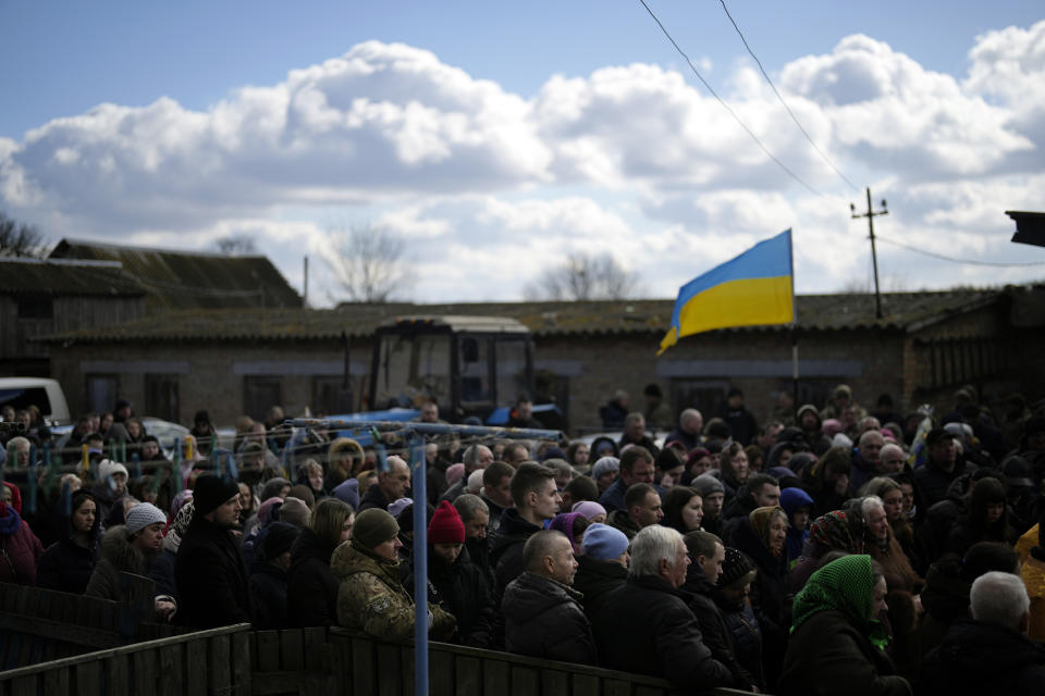Mourners gather next to the body of Vladyslav Bondarenko 26, during his funeral in Kozyntsi, near Kyiv, Ukraine, Monday, March 6, 2023. Bondarenko, a paratrooper of airmobile brigade, died near Bakhmut on Feb 26. (AP Photo/Thibault Camus)