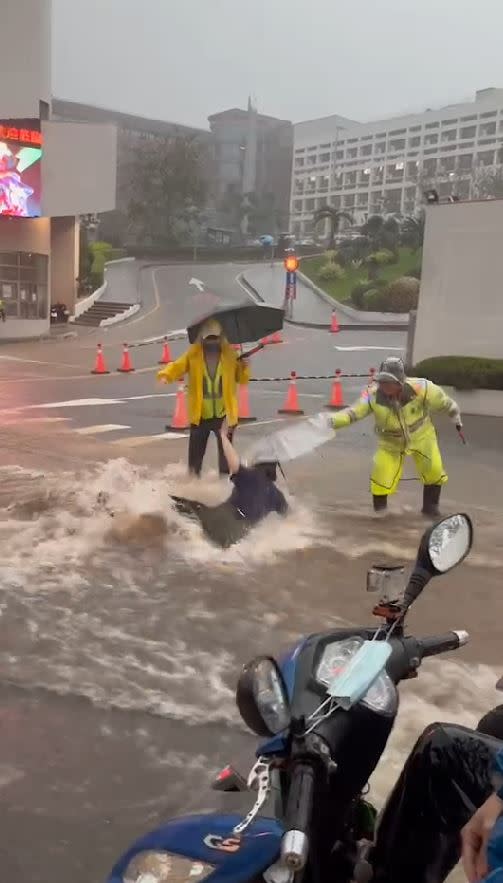 弘光科大前淹水變成急流，女學生撐傘涉水而過，慘遭湍急洪水沖走，險象環生。(圖／翻攝自記者爆料網)