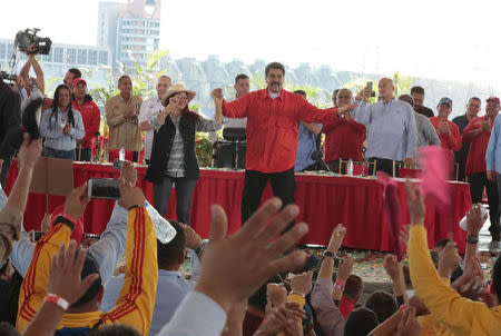 Venezuela's President Nicolas Maduro (C) greets workers next to his wife Cilia Flores, during a meeting at the Francisco de Miranda hydroelectric complex in Caruachi, Venezuela July 6, 2017. Miraflores Palace/Handout via REUTERS