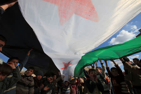 FILE PHOTO: Children chant slogans while marching with a Syrian independence flag during a demonstration against President Bashar al-Assad in Hazzano, Idlib province, Syria March 2, 2012. REUTERS/Zohra Bensemra/File Photo