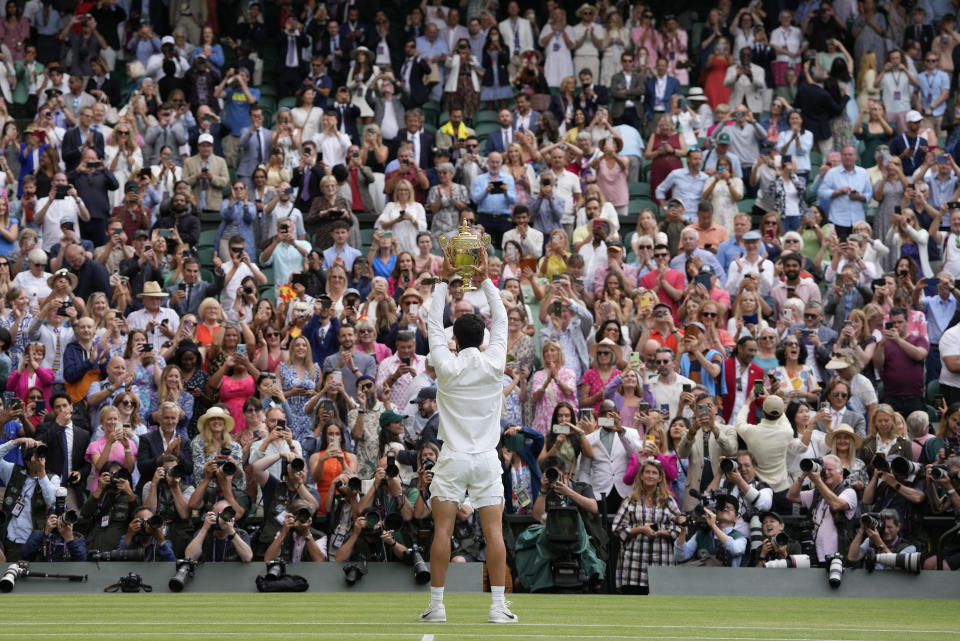 Spain's Carlos Alcaraz celebrates with the trophy after beating Serbia's Novak Djokovic to win the final of the men's singles on day fourteen of the Wimbledon tennis championships in London, Sunday, July 16, 2023. (AP Photo/Kirsty Wigglesworth)