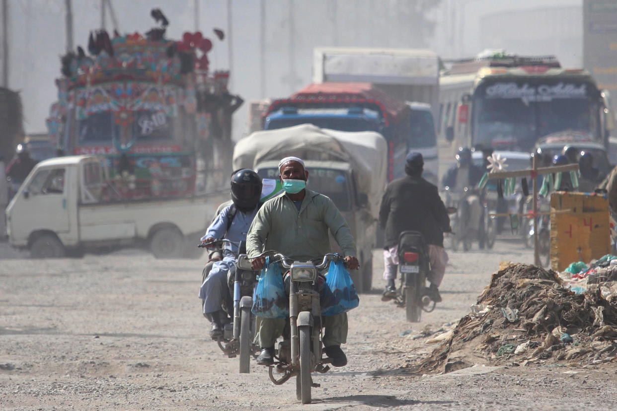 A man wears a face mask as he rides a motorcycle amid the ongoing COVID-19 pandemic in Pakistan (EPA)