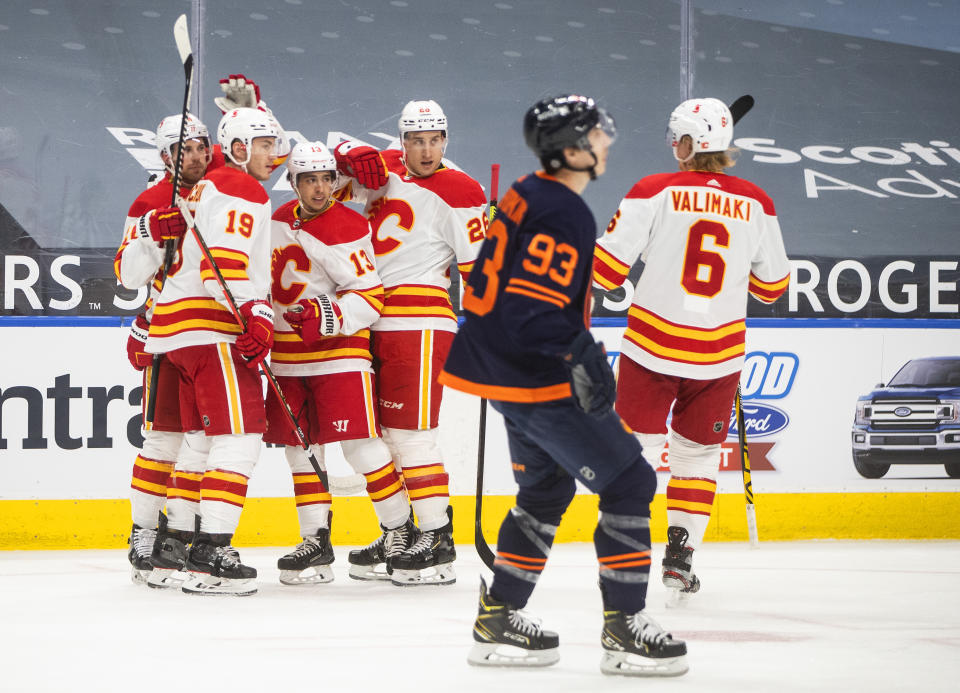 Edmonton Oilers' Ryan Nugent-Hopkins (93) skates past as Calgary Flames' Mikael Backlund (11), Matthew Tkachuk (19), Johnny Gaudreau (13), Michael Stone (26) and Juuso Valimaki (6) celebrate a goal during the first period of an NHL hockey game, Thursday, April 29, 2021 in Edmonton, Alberta. (Jason Franson/Canadian Press via AP)