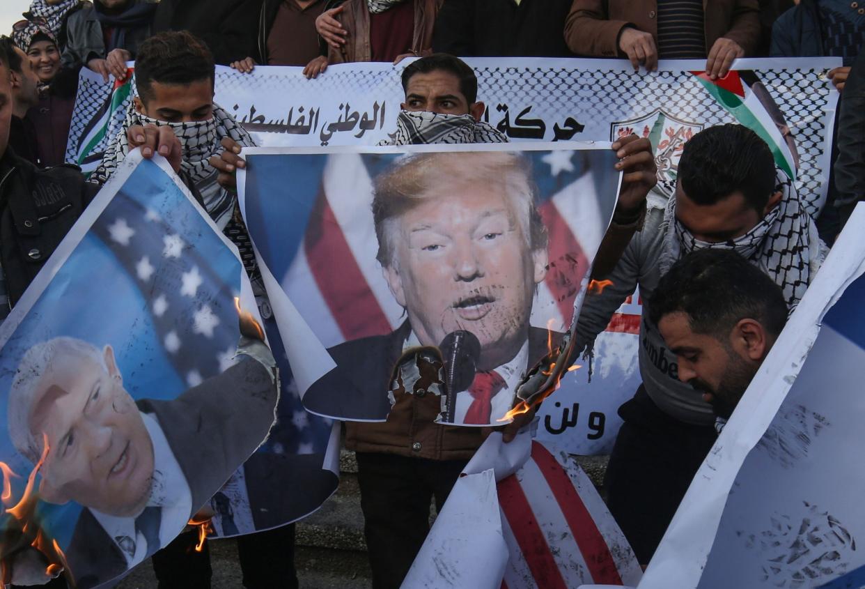 Palestinian demonstrators burn images of US President Donald Trump and Israeli Prime Minister Benjamin Netanyahu during a demonstration in Rafah in the southern Gaza Strip on Wednesday: AFP via Getty Images