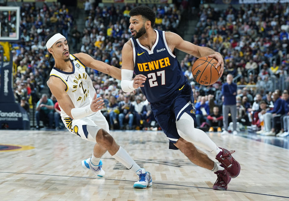 Denver Nuggets guard Jamal Murray, right, drives past Indiana Pacers guard Andrew Nembhard, left, in the second half of an NBA basketball game Sunday, Jan. 14, 2024, in Denver. (AP Photo/David Zalubowski)