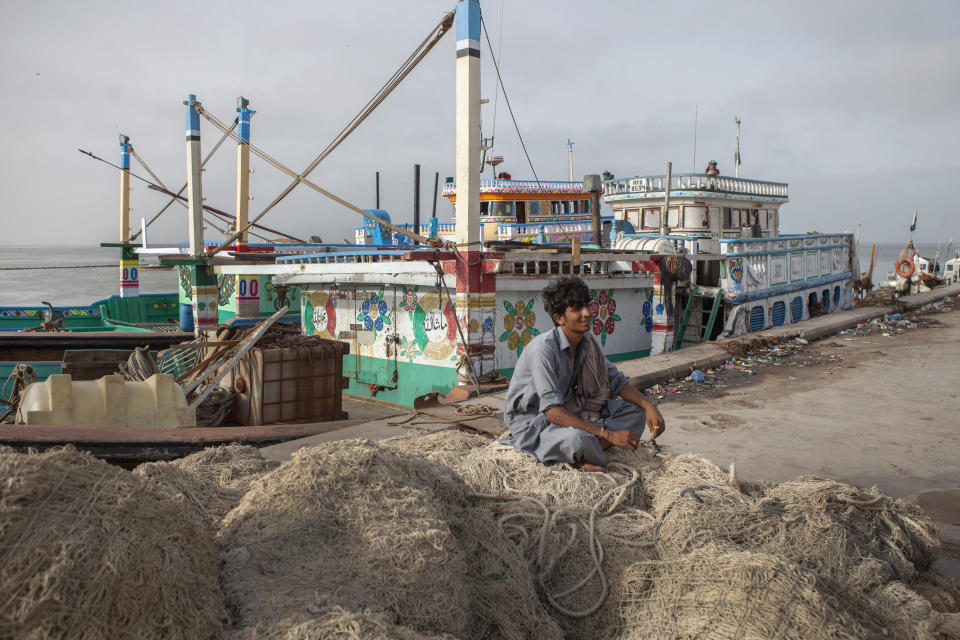 A fisherman sits on a pile of nets at a harbor in Gwadar, Balochistan, Pakistan, on Aug. 2, 2016. Gwadar is the cornerstone of China's project to rebuild the ancient trading route that connects China to the Arabian Sea, slicing through the Himalayas and crossing deserts and disputed territory to reach this ancient fishing port, about 500 miles by boat from Dubai.