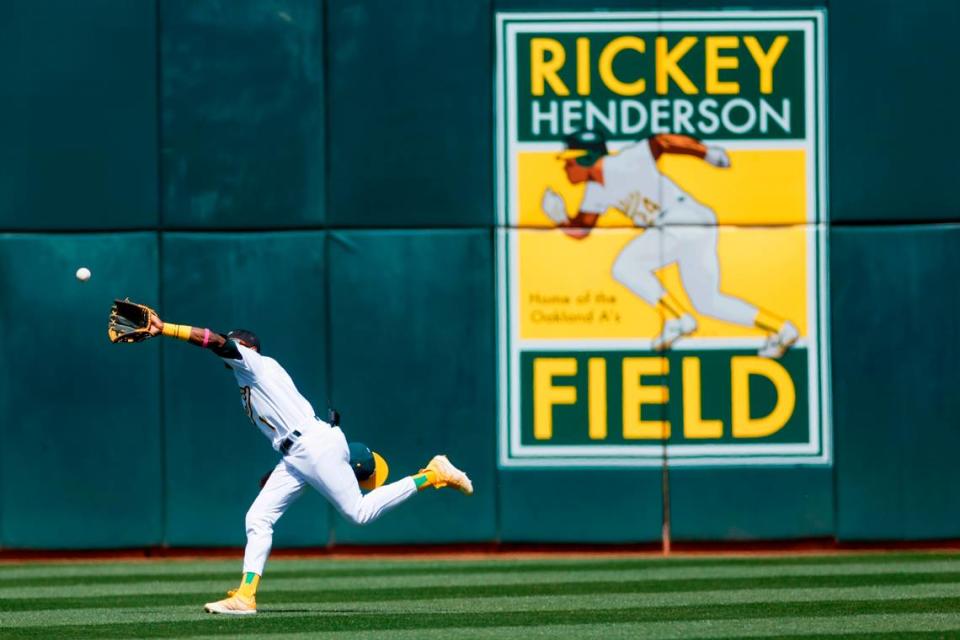 Oakland Athletics’ Esteury Ruiz (1) catches a fly ball against the Cleveland Guardians in the fourth inning at the Coliseum in Oakland on Tuesday, April 5, 2023, as a mural highlights the team’s Bay Area history in the background.