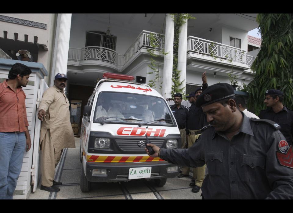 An ambulance removes dead bodies of shooting victims from a house in Lahore, Pakistan on Monday, April 30, 2012. The widow and mother-in-law of one of two Pakistanis men shot and killed by a CIA contractor last year, have been murdered in Lahore, police said. It appears the killings may have been related to the large amount of "blood money" Zohra Haider received to pardon her husband's killer, Raymond Davis. (AP Photo/K.M. Chaudary)