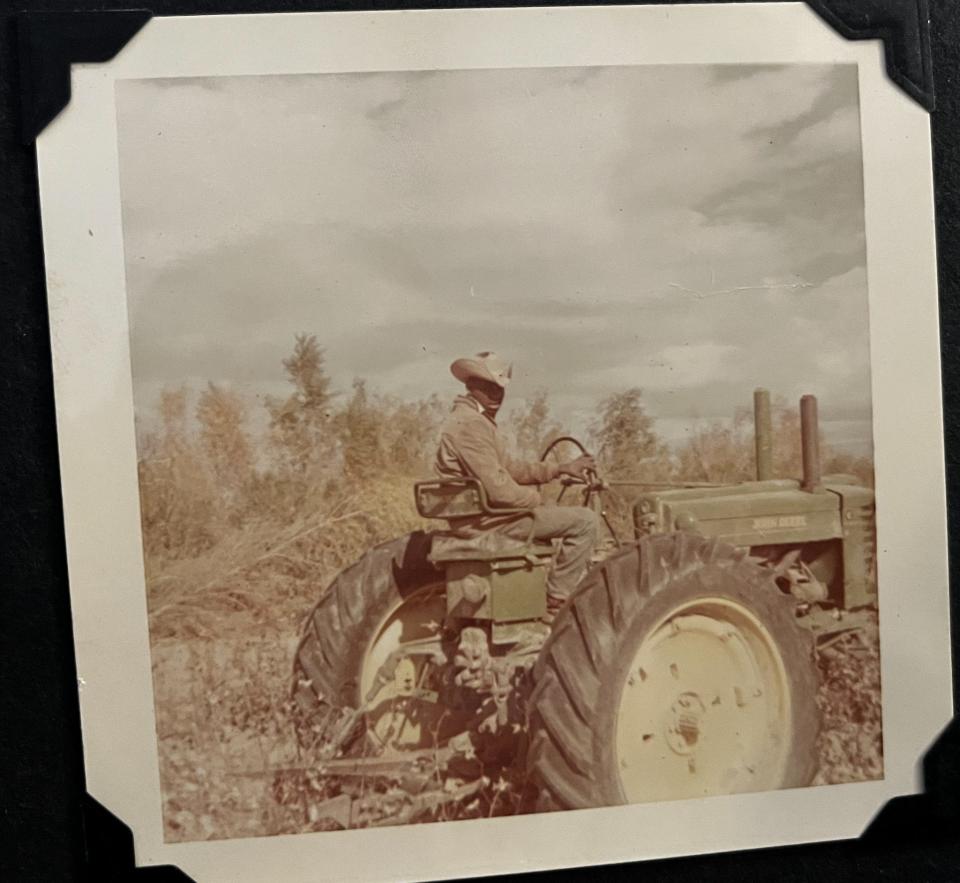 A photo of Elmo Dees sitting on a tractor on his family's farm.