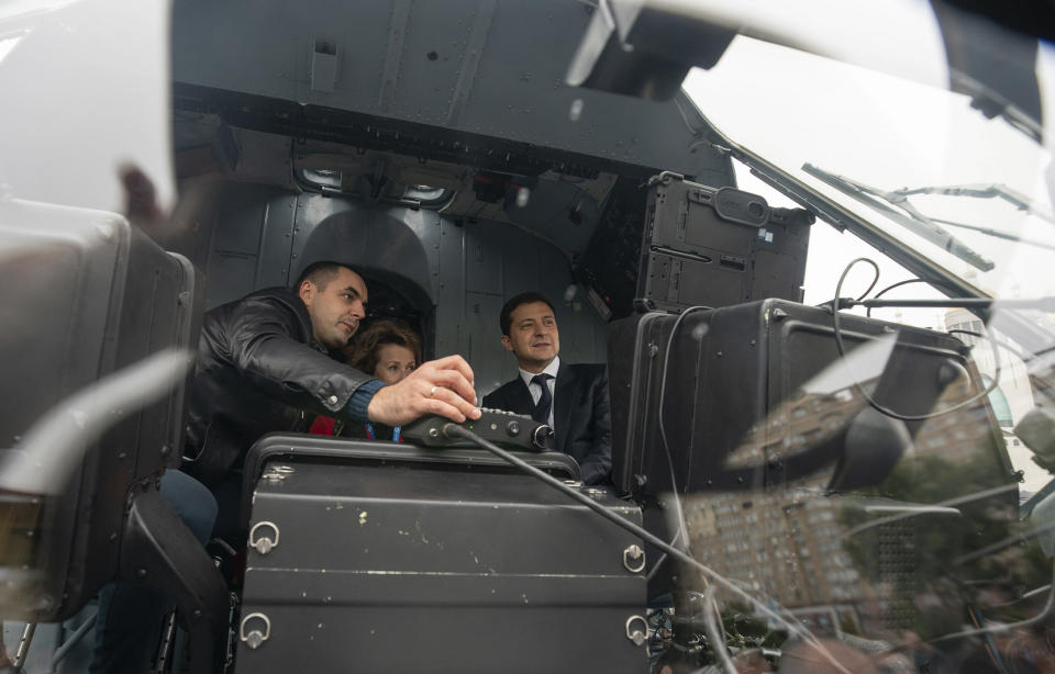 In this handout photo provided by the Ukrainian Presidential Press Office, Ukrainian President Volodymyr Zelenskiy, right, sits inside a military helicopter as he visits an arm exhibition in Kyiv, Ukraine, Wednesday, Oct. 9, 2019. (Ukrainian Presidential Press Office via AP)