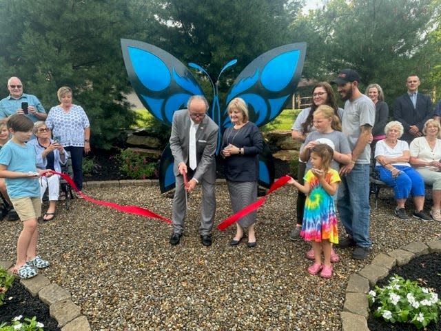 Alliance Mayor Andy Grove cuts the ribbon at the new Butterfly Garden at Silver Park as his wife, Sue, looks on Thursday, Sept. 7, 2023.