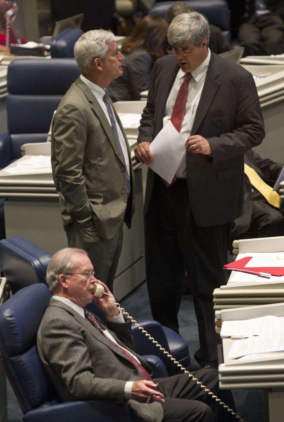 Sen. Trip Pittman, R-Daphne, top right, talks with Sen. Paul Bussman, R-Cullman, during the Senate session at the Alabama Statehouse in Montgomery, Ala., Thursday, April 19, 2012. At front is Sen. Jabo Waggoner, R-Vestavia Hills. The Alabama House and Senate are looking for a compromise on their different versions of a bill to tie legislators' pay to the state's median household income. The House voted 77-8 Thursday and the Senate voted 30-2 to send the pay bill to a conference committee of six legislators to seek a compromise. (AP Photo/Dave Martin)