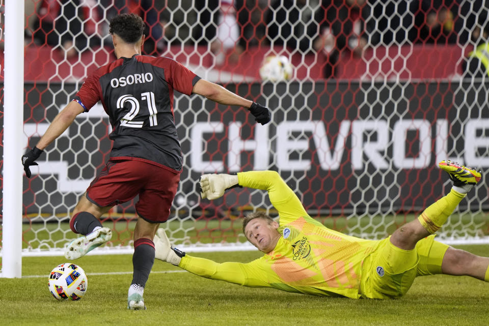 Toronto FC midfielder Jonathan Osorio (21) gets the ball past Sporting Kansas City goalkeeper Tim Melia, but there was an offside call, negating the apparent goal, during the first half of an MLS soccer match Saturday, March 30, 2024, in Toronto. T(Frank Gunn/The Canadian Press via AP)