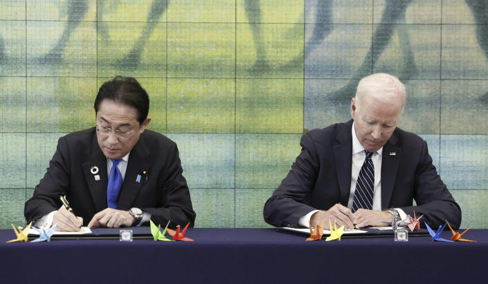 Japan's Prime Minister Fumio Kishida, left, and U.S. President Joe Biden sign a book during their visit at Hiroshima Peace Memorial Museum in Peace Memorial Park as part of the G7 Hiroshima Summit in Hiroshima, western Japan, Friday, May 19, 2023. (Kyodo News via AP)