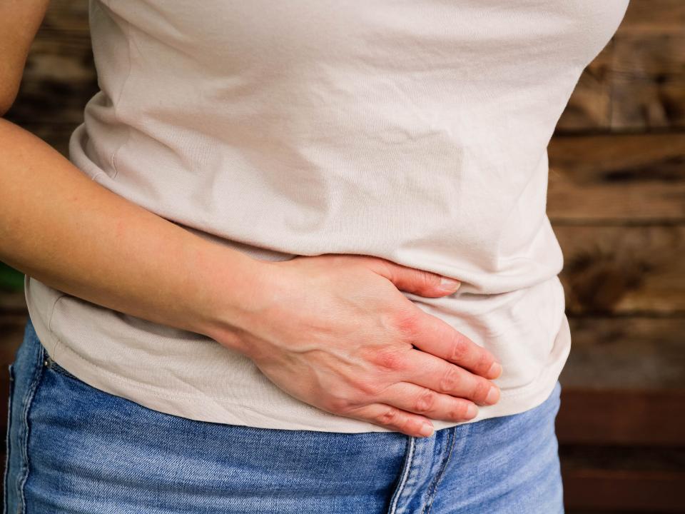 A woman holding her stomach in pain.