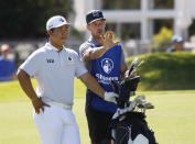 Si Woo Kim, left, of South Korea, confers with his caddie at the ninth hole during the first round of the Shriners Children's Open golf tournament at TPC Summerlin, Thursday, Oct. 6, 2022, in Las Vegas. (AP Photo/Ronda Churchill)