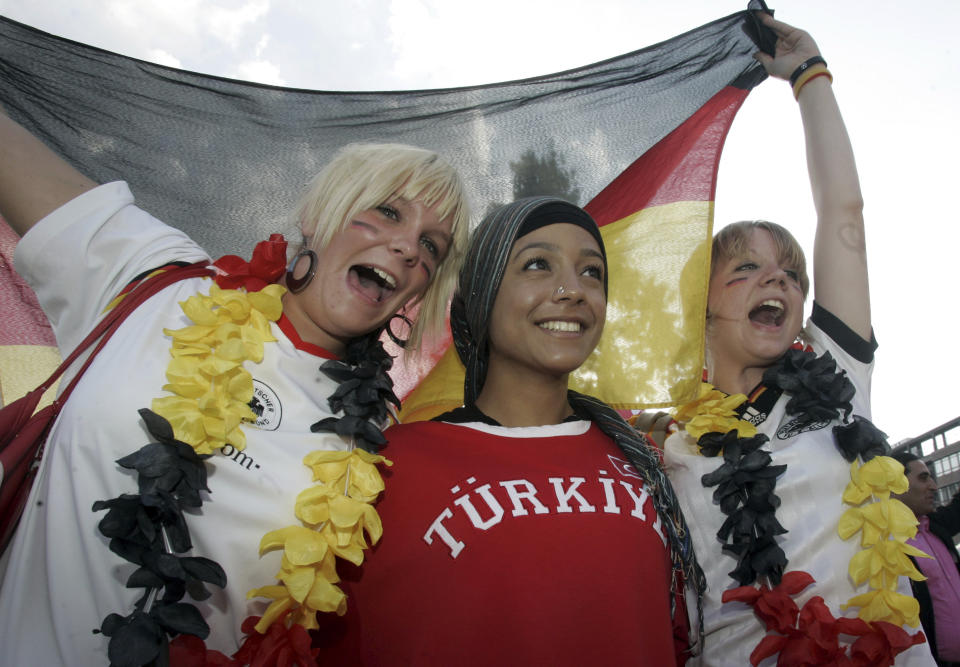 FILE - German and Turkish fans celebrate at the KoelnArena-Dome prior to the soccer EURO 2008 semi-final match between Germany and Turkey in Cologne, Germany, Thursday, June 25, 2008. “In Germany we’re going to be like a host country,” Turkey defender Ozan Kabak, who was born in Turkey but plays his club soccer in Germany, said in a recent interview. “A lot of Turkish people live here, and I think whole stadiums (are) going to be full of Turkish people." Fans of the Turkish team even outnumbered Germany’s supporters at the friendly in Berlin last year. (AP Photo/Roberto Pfeil, File)