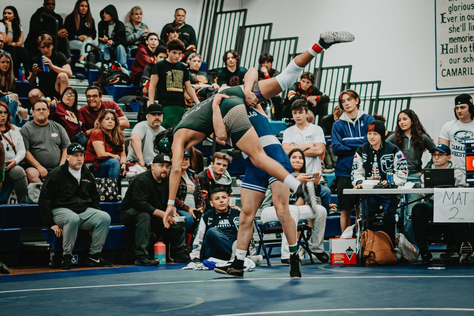 Camarillo High's Daniel Gurovich picks up Calvin Velasco of Royal in the 195-pound final during the Coastal Canyon League wrestling finals on Saturday at Camarillo High. Gurovich won the league title.