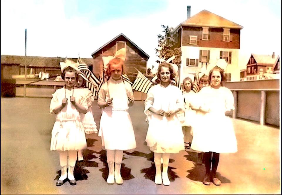 Marion McQuillian, left, was 8 years old on May 30, 1917, and in later years she recalled participating in Memorial Day and other patriotic activities during World War I. She and her classmates at Althea Street Elementary School in Providence dressed up in their Sunday best. Depending on the event, they carried flowers or flags to participate in memorial services or cheer on the veterans in a parade. (This colorized photo was probably taken on June 14, 1917 – Flag Day.)