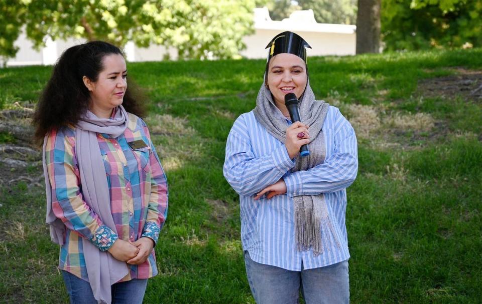 Enjila Farokh Ahmadi, right, talks about her experience going through IRC’s child-care microenterprise development program as IRC business counselor Halima Mohammadi, during a graduation ceremony at Davis Park in Modesto Calif., on Friday, July 1, 2022. Seventeen women refugees from Afghanistan are the first graduates of the International Rescue Committee and Modesto Junior College’s child care microenterprise development program for home child-care licensing.