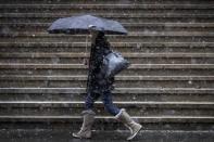 A morning commuter carries an umbrella through the cold and snow during the morning rush on Wall Street in New York's financial district March 5, 2015. REUTERS/Brendan McDermid