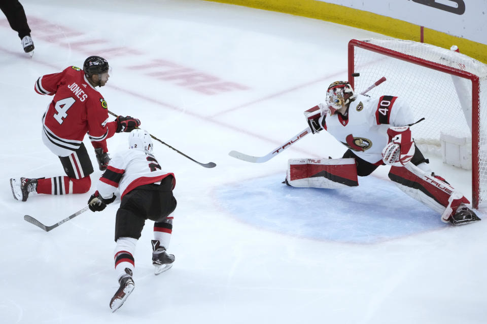 Chicago Blackhawks' Seth Jones (4) scores in the second period of an NHL hockey game as Ottawa Senators goaltender Mads Sogaard (40) and Artem Zub defend Monday, March 6, 2023, in Chicago. (AP Photo/Charles Rex Arbogast)