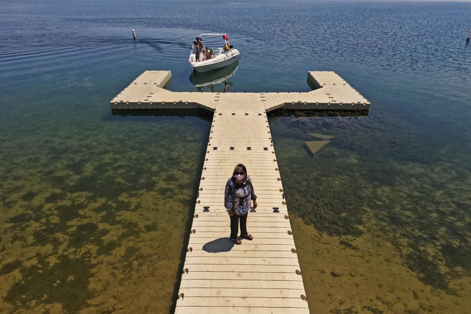 Delanna Mart stands on a dock at a lake on Ute Indian Tribe of the Uintah and Ouray Reservation, Monday, July 25, 2022, in Fort Duchesne, Utah. The divvying up between Colorado River Basin states never took into account Indigenous Peoples or many others, and from the start the calculation of who should get what amount of that water may never have been balanced. (AP Photo/Rick Bowmer)