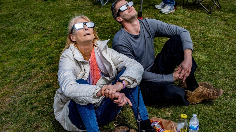 Debbie Palmer, 65, and her son David Palmer, 34, both of Dearborn Heights, watch the solar eclipse near the public beach In Luna Pier, Mich., on Monday, April 8, 2024. Palmer says this is a “once in a lifetime opportunity” to see the eclipse.