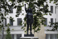 A new black resin and steel statue entitled "A Surge of Power (Jen Reid) 2020" by artist Marc Quinn stands after the statue was put up this morning on the empty plinth of the toppled statue of 17th century slave trader Edward Colston, which was pulled down during a Black Lives Matter protest in Bristol, England, Wednesday, July 15, 2020. On June 7 anti-racism demonstrators pulled the 18-foot (5.5 meter) bronze likeness of Colston down, dragged it to the nearby harbor and dumped it in the River Avon — sparking both delight and dismay in Britain and beyond. (AP Photo/Matt Dunham)