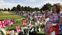 <p>A woman takes a photograph as people crowd around the gates of Kensington Palace in London to pay tribute to the late Diana, Princess of Wales, Aug. 31, 2017. (Photo: Kirsty Wigglesworth/AP) </p>