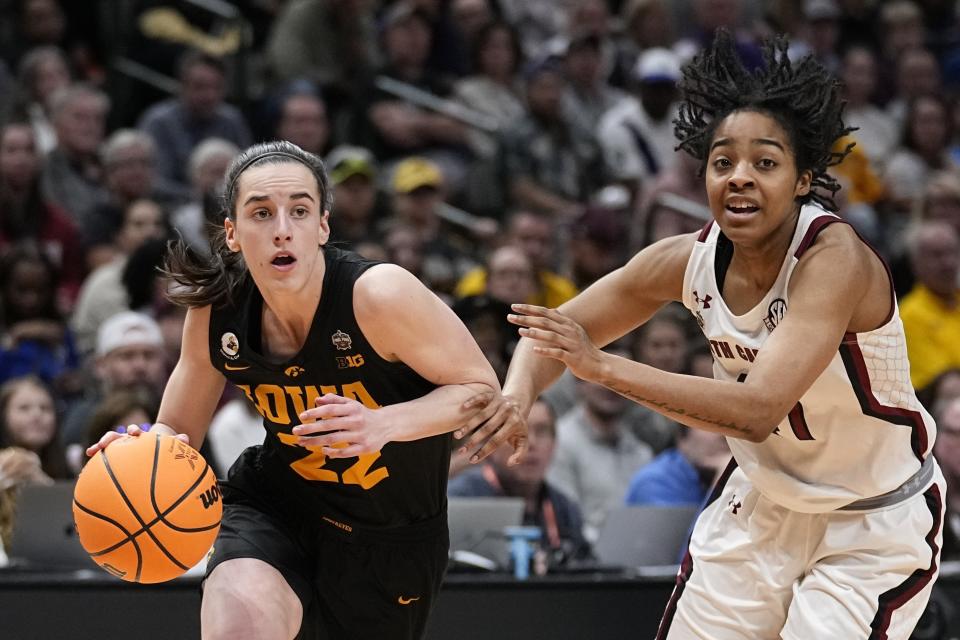 FILE -Iowa's Caitlin Clark gets past South Carolina's Kierra Fletcher during the second half of an NCAA Women's Final Four semifinals basketball game Friday, March 31, 2023, in Dallas. How well do you think you know the women’s NCAA Tournament? Try your luck at this AP trivia quiz about the history of March Madness. Don’t cheat! (AP Photo/Tony Gutierrez, File)