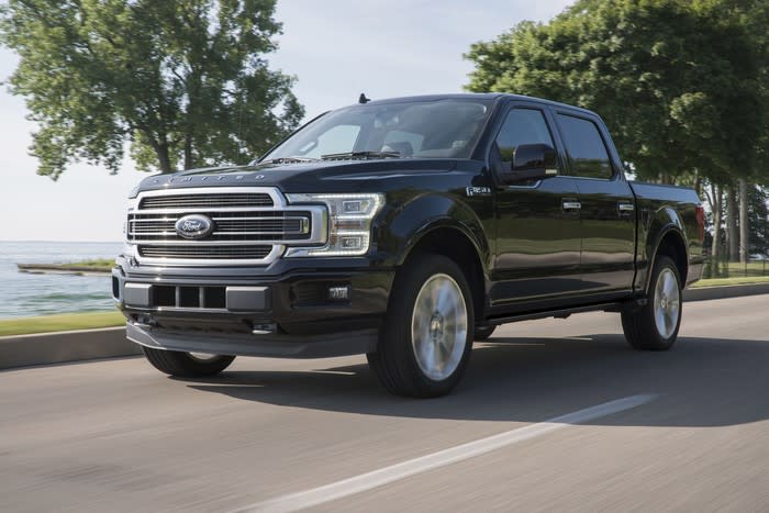 A black 2019 Ford F-150 Limited, an upscale full-size pickup truck, on a coastal road.