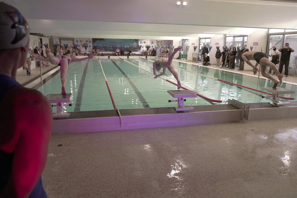 Swimmers race at the public swimming pool in the Paris-region town of Sevran Wednesday, Jan. 24, 2024. The town of 51,000 people in the Seine-Saint-Denis region north of Paris is inheriting one of the pools that will be used for the Olympic and Paralympic Games in Paris this summer. The 50-meter pool Olympic pool for Sevran will be a significant upgrade. Its existing 25-meter pool is nearly 50 years old. (AP Photo/John Leicester)