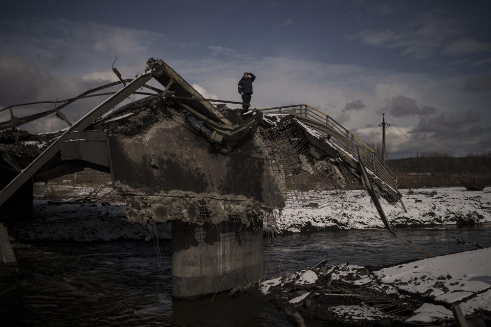 A man stands atop a destroyed bridge in Irpin, on the outskirts of Kyiv. 