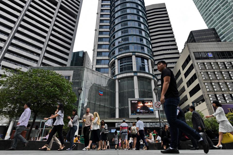 People walk along the Raffles Place business district in Singapore on September 5, 2018. (Photo by Roslan RAHMAN / AFP)        (Photo credit should read ROSLAN RAHMAN/AFP/Getty Images)