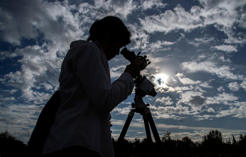 Linda Yin of Stockton looks at the solar eclipse through a telescope equipped with a protective filter during a watch party held by the Delta College Physics-Math-Computer Sciences Club and the the Stockton Astronomical Society on the campus of San Joaquin Delta College in Stockton on Oct. 14, 2023. It began at about 8 a.m. and lasted until about 10:40 a.m. with its peak at about 9:30 a.m. About 50 people attended the event. A solar eclipse is when the moon comes between the Earth and Sun. Stockton was just outside of the eclipse's path and experiences only a partial eclipse covering most but all of the Sun. The Oct. 14 eclipse was an annular eclipse. That's when the moon is at its farthest from the Earth and it doesn't entirely block out the Sun but leaves a ring often called the "ring of fire." A total eclipse will occur on April, 8 2024.