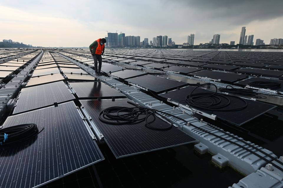 A worker checks cables on a floating solar power farm at sea off Singapore’s northern coast on 22 January, 2021.  (AFP/Getty)