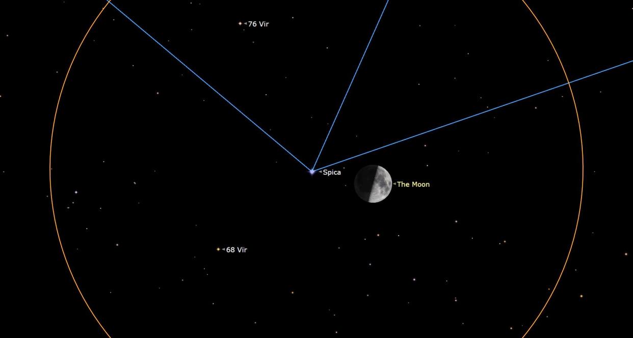  The outline of an orange circle floats in the center of a black, starry sky, its top and bottom to massive to fit in frame. In the center, a bright star Spica shoots out three blue lines diagonally left and right, and one upward slightly right. A quarter moon shines to the right of Spica. 