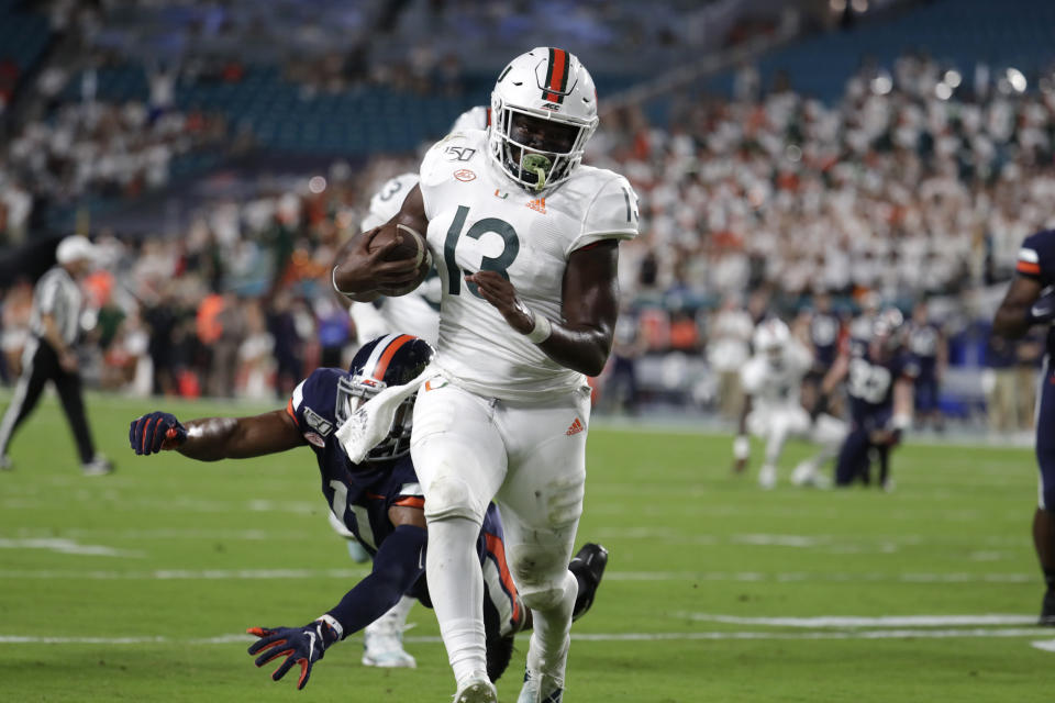 Miami running back DeeJay Dallas (13) runs past Virginia linebacker Charles Snowden to score a touchdown during the first half of an NCAA college football game, Friday, Oct. 11, 2019, in Miami Gardens, Fla. (AP Photo/Lynne Sladky)