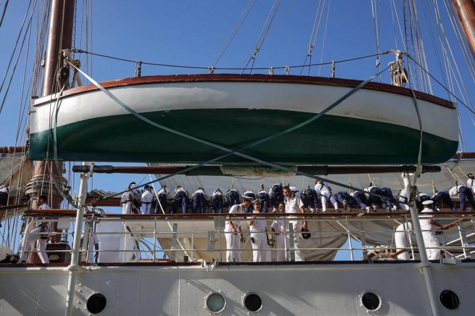 Sailors roll the sails and officers share a laugh as Juan Sebastián de Elcano docks at Maurice A. Ferré Park at the port of Miami, Florida, on Wednesday, May 18, 2022.