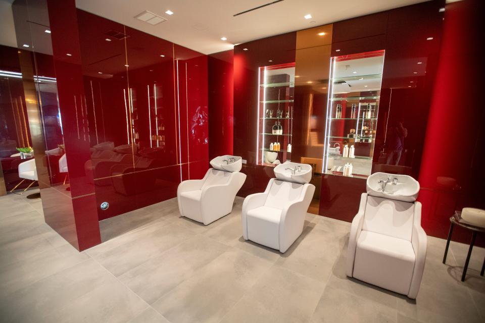 a red beauty salon room with three white chairs at mansion The One Bel Air