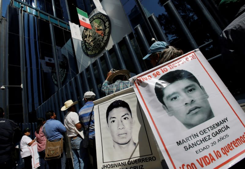FILE PHOTO: Relatives hold poster with images of some of the 43 missing students of Ayotzinapa College Raul Isidro Burgos as they take part in a protest, in Mexico City