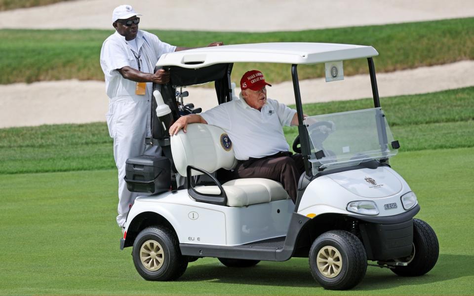Donald Trump drives his buggy in front of the green and is told to move - GETTY IMAGES