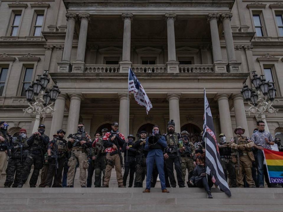 The Boogaloo Boys stand on the steps of the Capitol Building during a rally on October 17, 2020 in Lansing, Michigan.